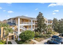Two-story condo building with inviting landscaping and ample parking at 114 Rum Run, Davenport, FL 33837