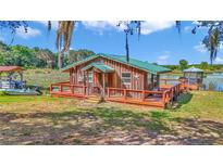 Charming waterfront cottage with a wooden deck, dock, and boat on a picturesque lake at 15040 Ne 248Th Avenue Rd, Fort Mc Coy, FL 32134