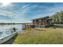 Quaint waterfront cabin with wood siding, a spacious deck, and beautiful lake views at 15040 Ne 248Th Avenue Rd, Fort Mc Coy, FL 32134