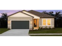 One-story home with gray siding, dark gray garage door, and landscaping at 1609 Hill Park Dr, Deltona, FL 32725