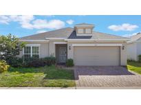 Charming single-story home featuring a brick driveway and well-maintained landscaping at 253 Golden Sands Cir, Davenport, FL 33837