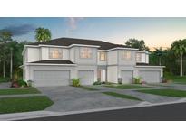Two-story townhome with gray siding, three-car garage, and landscaping at 2582 Winsome Way, Davenport, FL 33896