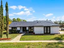 Charming single-story home featuring a unique stone facade, metal roof, and well-maintained landscaping at 3523 Medford Rd, Casselberry, FL 32707