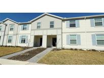 Two-story townhome with light-colored siding, and a landscaped front yard at 4114 Lana Ave, Davenport, FL 33897