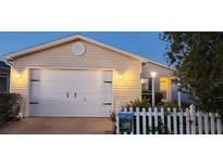 Charming single-Gathering home features a two-car garage, complemented by a white picket fence and fresh landscaping at 482 Hildalgo Dr, The Villages, FL 32159