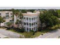Three-story building with balconies, palm trees, and street view at 7521 Mourning Dove Cir # 303, Reunion, FL 34747