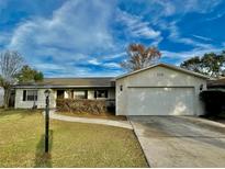 Single story home with attached garage and well-maintained lawn at 115 Cardamon Dr, Orlando, FL 32825