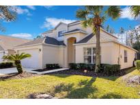 Two-story house with a two-car garage and landscaped lawn at 136 Madiera Beach Blvd, Kissimmee, FL 34746