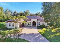 Single-story home with tile roof, large driveway, and lush landscaping at 1829 Brackenhurst Pl, Lake Mary, FL 32746