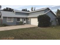 View of the home's front featuring gray exterior paint, new roof, and attached garage at 1886 Elkcam Blvd, Deltona, FL 32725