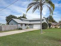 Charming single-story home with lush green lawn, mature palm tree, and paved driveway at 1886 Elkcam Blvd, Deltona, FL 32725