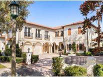 Stunning two-story home with tile roof, arched entryway, and gated courtyard at 236 Acadia Ter, Celebration, FL 34747