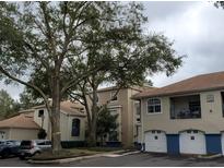 Exterior view of condo building with parking and landscaping at 7220 Westpointe Blvd # 1421, Orlando, FL 32835
