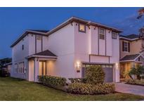 Contemporary two-story home with manicured landscaping, neutral color scheme, and attached garage at 7623 Wilmington Loop, Kissimmee, FL 34747