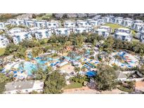 Aerial view of a community with resort-style pool and numerous residences at 7740 Sandy Ridge Dr # 127, Reunion, FL 34747
