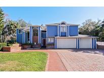 Two-story home with blue siding, brick driveway, and two-car garage at 2395 Windward Cv, Kissimmee, FL 34746