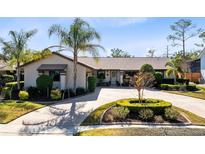 Charming home featuring a circular driveway, lush landscaping, and a well-maintained front yard at 489 Sugar Ridge Ct, Longwood, FL 32779