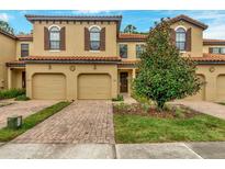 Charming two-story townhome with a terracotta roof, attached garage, and landscaped front yard at 8189 Roseville Rd, Davenport, FL 33896