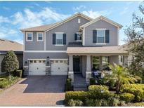 Two-story home with gray siding, two-car garage, and landscaped yard at 9459 Jaywood Rd, Winter Garden, FL 34787