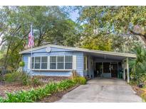 Cute light blue manufactured home with covered carport and mature landscaping at 151 E Plantation Blvd, Lake Mary, FL 32746