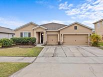 Charming single-story home with a well-maintained lawn, two-car garage, and inviting curb appeal at 1882 Rustic Falls Dr, Kissimmee, FL 34744