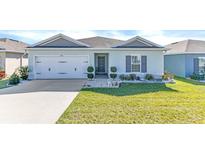 One-story home with gray siding, white garage door, and landscaped lawn at 206 Piave St, Haines City, FL 33844