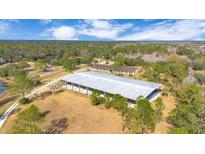 Aerial view of equestrian property with large arena, barns, and paddocks at 2140 W State Road 46, Geneva, FL 32732