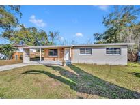 Home exterior showing the front yard, driveway and some trees at 3309 Drake Dr, Orlando, FL 32810