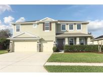 Charming two-story home featuring a well-manicured lawn, complemented by a three-car garage and neutral color palette at 341 Skyview Pl, Chuluota, FL 32766
