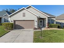 Charming single-story home with a two-car garage, well-maintained landscaping, and neutral-colored stucco exterior at 3608 Mount Hope Loop, Leesburg, FL 34748