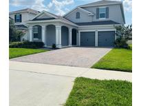 Charming two-story home featuring a brick driveway, attached two-car garage, and well-maintained front lawn at 4425 Lions Gate Ave, Clermont, FL 34711