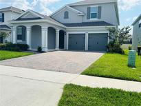 Beautiful two-story home with a brick driveway and manicured lawn at 4425 Lions Gate Ave, Clermont, FL 34711