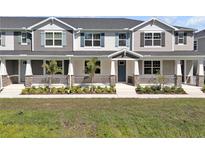 Charming townhome featuring a welcoming front porch, stone accents, and well-maintained landscaping at 1281 Coral Bean Ln, Winter Springs, FL 32708