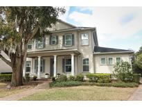 Beautiful two-story home with a well-manicured lawn, inviting front porch, and charming architectural details at 179 Hillcrest Dr, Oviedo, FL 32765