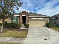 Charming single-story home with a well-manicured lawn, two car garage, and a stone-accented entryway at 2931 Top Water Way, Kissimmee, FL 34746