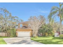 Two-story house with a white garage door and landscaped lawn at 4292 Lillian Hall Ln, Orlando, FL 32812