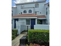 Inviting two-story condo with a red tile roof, blue painted stucco, and manicured landscaping at 4826 Marks Terrace # 389, Orlando, FL 32811