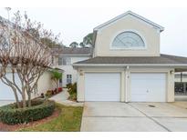 Two-story townhome with a two-car garage and landscaped walkway at 5999 Lake Pointe # 609, Orlando, FL 32822