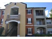 Three-story condo building with balconies and painted in warm tones with dark shutters at 700 Crest Pines Dr # 133, Orlando, FL 32828
