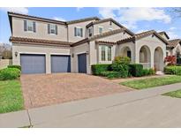 Charming two-story home boasts a three-car garage and a brick-paved driveway at 9573 Meadow Hunt Way, Winter Garden, FL 34787
