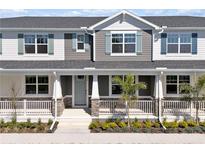 Charming townhome featuring stone accents, blue shutters and a covered porch with white railings at 1317 Coral Bean Ln, Winter Springs, FL 32708