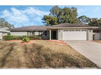 Ranch style home with attached garage and well-manicured lawn at 1357 Sterling Oaks Dr, Casselberry, FL 32707