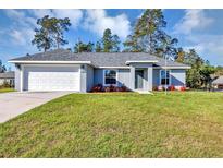 Charming single-story home featuring a well-manicured lawn and an attached two-car garage at 17008 Sw 32Nd Ter, Ocala, FL 34473