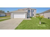 Charming two-story home featuring a well-maintained lawn and attached two-car garage at 2120 Marisol Loop, Kissimmee, FL 34743