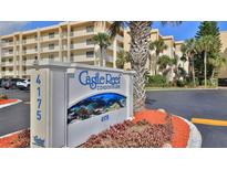 Condominium exterior view showcasing the building and signage, complemented by mature landscaping at 4175 S Atlantic Ave # 232, New Smyrna Beach, FL 32169