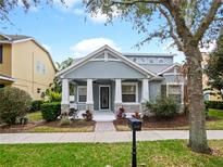Gray craftsman style home with front porch and landscaped yard at 6558 Helmsley Cir, Windermere, FL 34786
