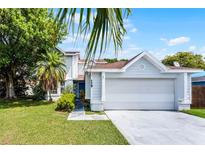 Inviting home featuring lush landscaping, a spacious two-car garage, and a well-maintained front yard at 119 Floral Ct, Kissimmee, FL 34743