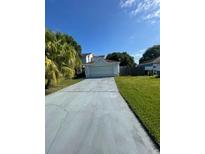 Charming single-Gathering home with a well-maintained lawn and a long driveway leading to a two-car garage at 119 Floral Ct, Kissimmee, FL 34743