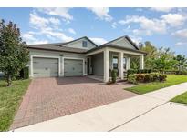 Inviting single-story home featuring a well-maintained front yard and brick-paved driveway leading to a two-car garage at 13557 Parkfield Way, Winter Garden, FL 34787