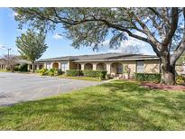 Building exterior showcasing a charming building with lush landscaping and ample parking at 208 Diamond Cv # 104, Casselberry, FL 32707